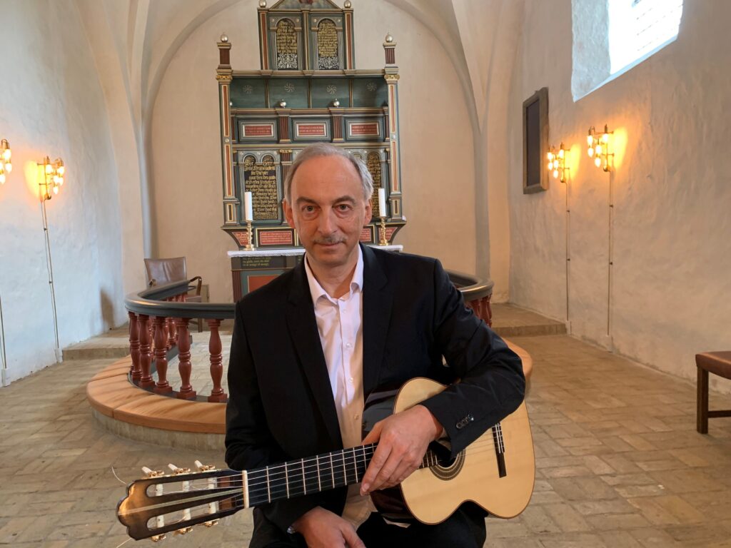 Carsten Pedersen spiller klassisk guitar siddende indendørs