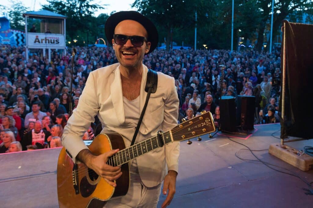Dennis Flacheberg spiller guitar på en festivalscene