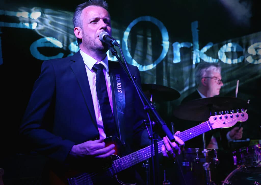 Festorkestret, bassist på scenen med banner