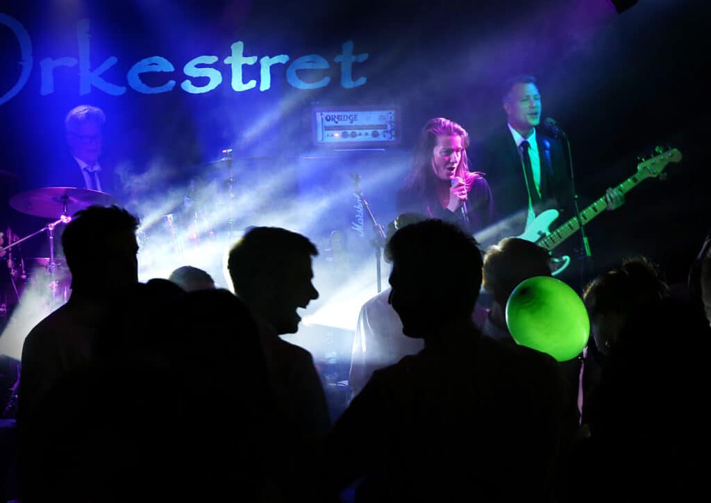 Festorkestret på scenen i blåt lys