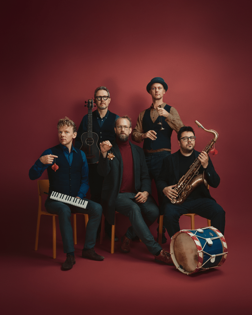 Acoustic Lounge poserer mod rød baggrund