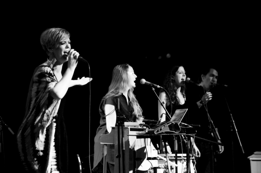 Anna Klinkby med band på en mørk scene