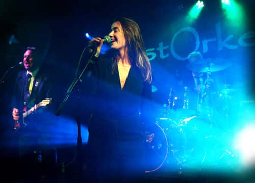 Festorkestret på scenen i blåt lys