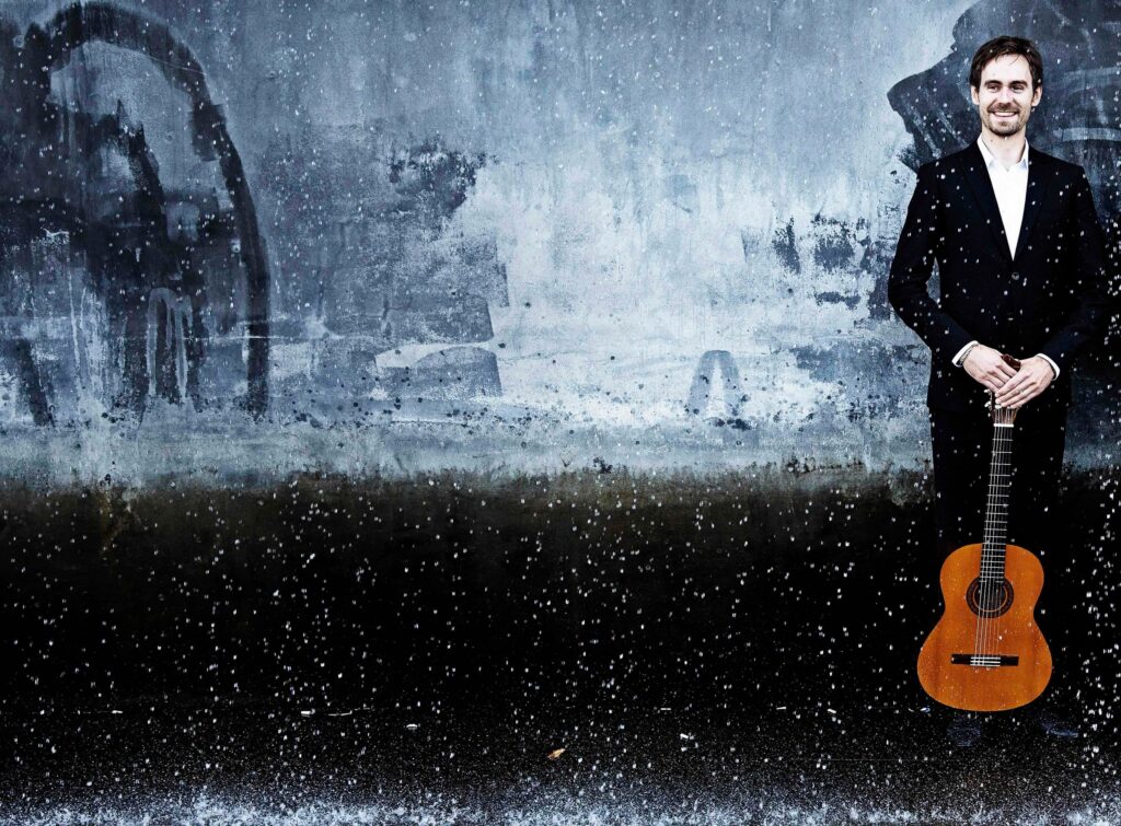 Martin Buono med guitar i et vintertåget landskab