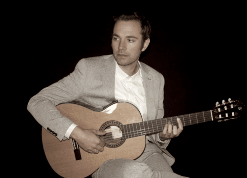 The Soulful Singer spiller akustisk guitar siddende
