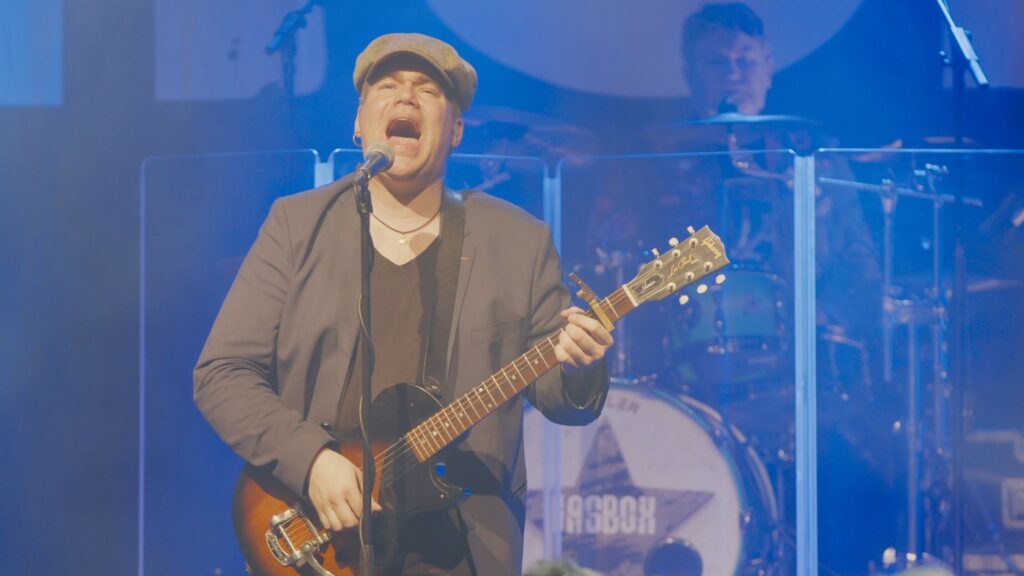 Gasbox, musiker med kasket og guitar