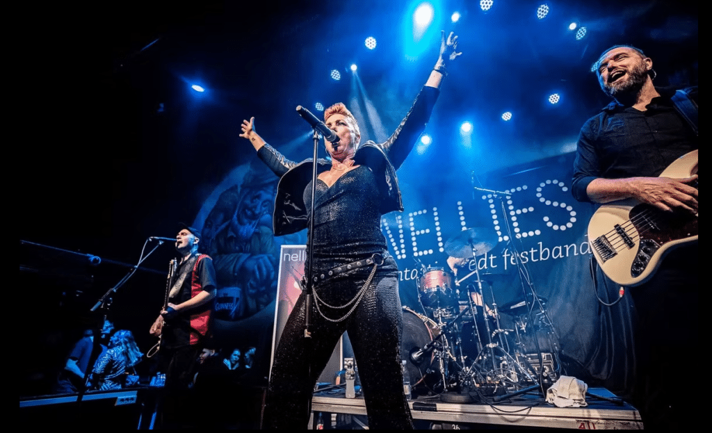 Nellies, kvindelig sanger på scenen med banner