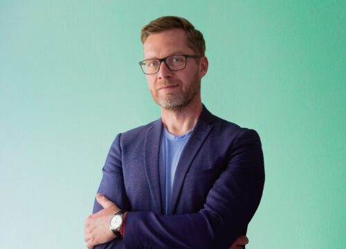 Lasse Rimmer i lilla blazer på mintgrøn baggrund