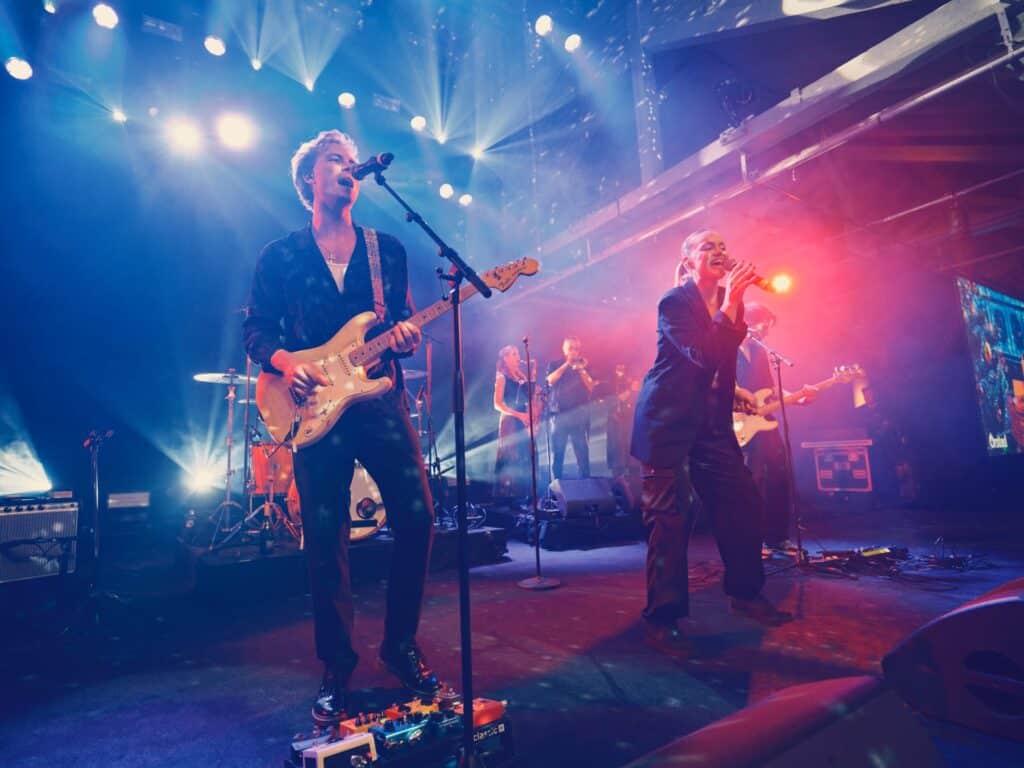 Forsanger fra HouseKeepers med guitar i rødt lys