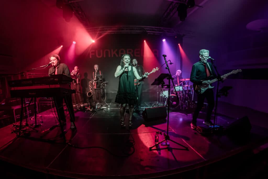 Funkarella på scenen i totalbillede med pink lys