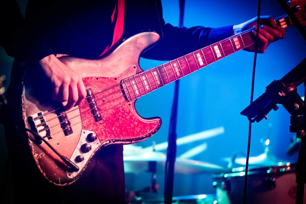 Nærbillede af bassist fra Funkarella i blåt lys