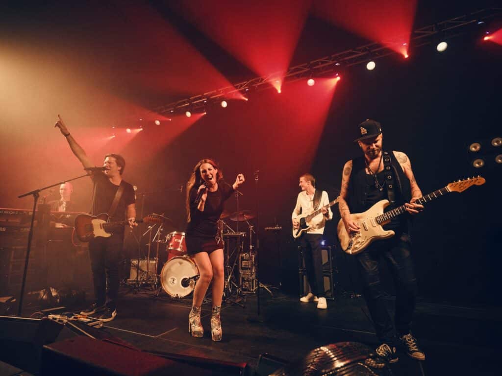 MoveYourFeet på scenen i rødt lys med guitarer