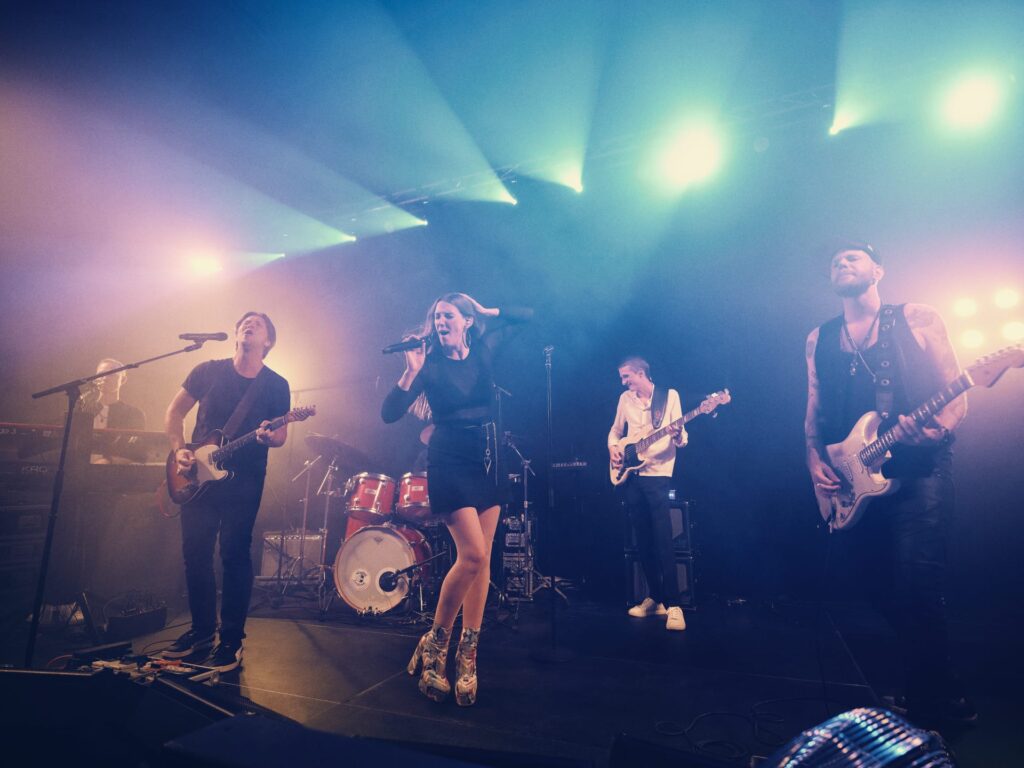 MoveYourFeet liveband i blåt scenelys med trommer
