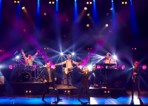 Prime spiller live på scenen, totalbillede af bandet