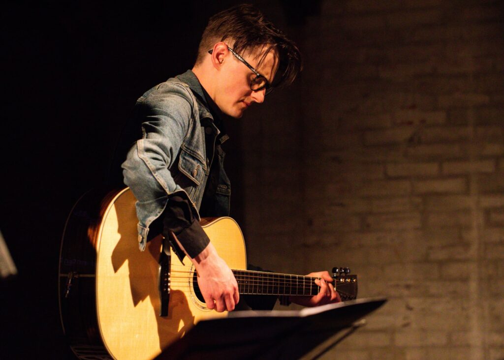 Lukas og Marius spiller akustisk guitar siddende